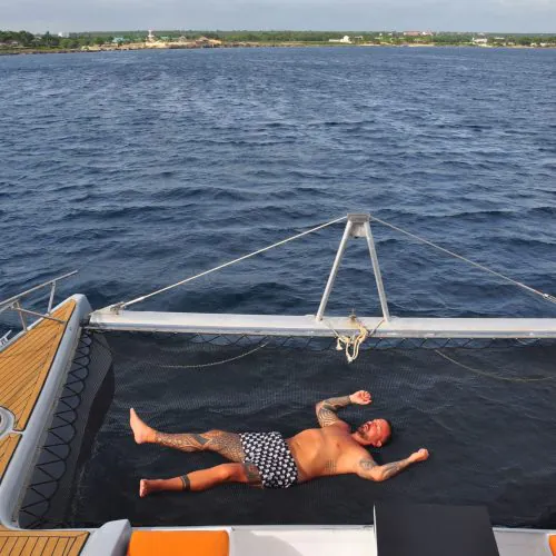 5 - Happy guest playing games while enjoying sunbath on our private yacht to Saona Island tour